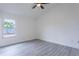 Well-lit bedroom with gray flooring, a large window and a ceiling fan at 4548 Summergrove Ave, Orlando, FL 32812