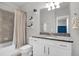 Clean bathroom with granite countertop, white cabinets, and tiled shower/tub at 590 Piazza Pt, Oviedo, FL 32765