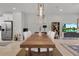 Elegant dining room featuring a long wooden table and modern chandelier at 590 Piazza Pt, Oviedo, FL 32765