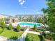 Community pool with lounge chairs, a patio, and lush green landscaping at 590 Piazza Pt, Oviedo, FL 32765