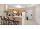 Kitchen with breakfast bar, white appliances, and wood cabinets at 3174 Feltrim Pl # 201, Kissimmee, FL 34747