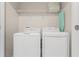 Bright laundry room with washer and dryer and overhead shelving at 2874 Stanza Ct, Kissimmee, FL 34746