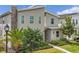 Modern two-story house with light beige exterior, stone chimney, and landscaped front yard at 2874 Stanza Ct, Kissimmee, FL 34746
