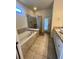 Bathroom with soaking tub, walk-in shower, and granite vanity at 2442 Tangier Dr, Kissimmee, FL 34747