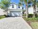 Two-story house with gray brick driveway and lush landscaping at 8914 Zurich Ln, Kissimmee, FL 34747