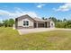 Tan two-story house with three-car garage and paver driveway at 19421 Oberly Pkwy, Orlando, FL 32833