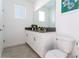 Clean bathroom with double vanity, modern fixtures, and gray tile flooring at 4326 Scene Ln, Kissimmee, FL 34746
