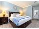 King-size bed with a blue blanket, and two nightstands with lamps at 4326 Scene Ln, Kissimmee, FL 34746