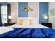 King bed with blue blanket and decorative wall art at 4326 Scene Ln, Kissimmee, FL 34746