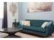 Teal couch, coffee table, and wall art in a living room at 4326 Scene Ln, Kissimmee, FL 34746