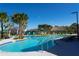 Large resort-style pool with lounge chairs and palm trees at 4326 Scene Ln, Kissimmee, FL 34746