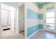 Bright hallway with teal and white striped wall and access to bathroom at 4326 Scene Ln, Kissimmee, FL 34746