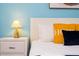 Bedroom with a white nightstand, lamp, and yellow and blue pillows at 4326 Scene Ln, Kissimmee, FL 34746