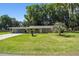 Ranch-style home with carport and lush lawn at 1009 Loves Point Dr, Leesburg, FL 34748