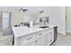 Kitchen island with white cabinets, quartz countertops, and stainless steel sink at 8103 Coconut Place, Kissimmee, FL 34747
