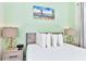 King-size bed in a bedroom with light walls and beach art at 8103 Coconut Place, Kissimmee, FL 34747
