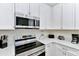 Modern kitchen with stainless steel appliances and white cabinets at 8103 Coconut Place, Kissimmee, FL 34747