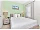 King-size bed in a bedroom with light walls and beach art at 8103 Coconut Place, Kissimmee, FL 34747