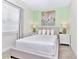 Bedroom with queen bed, light green accent wall, and bedside tables at 8103 Coconut Place, Kissimmee, FL 34747