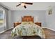 Main bedroom with leafy bedding, wood-look floors, and ceiling fan at 4223 Arlington Ridge Blvd, Leesburg, FL 34748