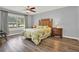 Main bedroom with leafy bedding, wood-look floors, and ceiling fan at 4223 Arlington Ridge Blvd, Leesburg, FL 34748