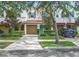 Front view of a light peach townhouse with a garage and lush landscaping at 734 Marotta Loop, Ocoee, FL 34761