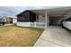 Mobile home with carport, screened porch, and white picket fence at 1785 Quail Hill Dr, Lakeland, FL 33810