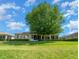 Home's backyard features a large tree and lush lawn at 2172 Nw 50Th Cir, Ocala, FL 34482