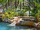 Relaxing pool area with waterfall feature and lush landscaping at 1911 Lake Markham Preserve Trl, Sanford, FL 32771