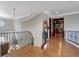 Upper hallway with hardwood floors, wrought iron railing, and views to lower level at 1911 Lake Markham Preserve Trl, Sanford, FL 32771