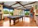 Game room with a pool table, hardwood floors, and large windows at 1911 Lake Markham Preserve Trl, Sanford, FL 32771