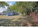Spacious backyard with covered patio, mature trees, and brick wall at 1112 Royal Marquis Cir, Ocoee, FL 34761