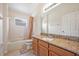 Clean bathroom with granite countertop, wood cabinets and a tub at 1112 Royal Marquis Cir, Ocoee, FL 34761
