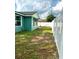 Freshly painted teal home with a side yard and white fence at 2015 1/2 Laurel St, Bartow, FL 33830
