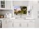 White kitchen with marble countertops and a window overlooking the backyard at 1305 W Lake Mary Blvd, Lake Mary, FL 32746