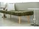 Green velvet bench with wooden legs and pillows sits in front of window at 1305 W Lake Mary Blvd, Lake Mary, FL 32746