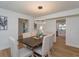 Bright dining room with a wood table, six chairs, and a modern light fixture, open to kitchen at 965 Tuskawilla Rd, Winter Springs, FL 32708