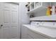 Bright laundry room with washer, dryer, and built-in shelving at 2938 Daybreak Dr, Orlando, FL 32825