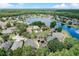 Aerial view of a house and neighborhood with a lake and lush green trees at 2938 Daybreak Dr, Orlando, FL 32825