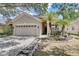 Two-story home with a beige exterior, a double-car garage, and a landscaped yard at 2938 Daybreak Dr, Orlando, FL 32825