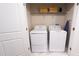 White laundry closet with washer, dryer, and shelving at 2965 Fable St, Kissimmee, FL 34746