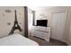Bright bedroom with a dresser, TV, and Paris-themed wall decor at 2965 Fable St, Kissimmee, FL 34746