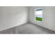 Simple bedroom with gray carpet and a window overlooking backyard at 4321 Carrabelle River Ln, Lakeland, FL 33811