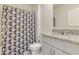 Clean bathroom with granite vanity and geometric shower curtain at 418 Anne St, Deland, FL 32724