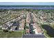 Aerial view of a community with a home highlighted, featuring tennis courts and a pond at 59 Chippingwood Ln, Ormond Beach, FL 32176