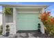 Modern light green garage door with landscaping at 59 Chippingwood Ln, Ormond Beach, FL 32176