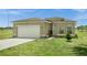 Tan house with white garage door and landscaping at 139 Columbia Dr, Kissimmee, FL 34759