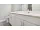 Double vanity bathroom with white cabinets and quartz countertop at 7557 Laureate Blvd # 6208, Orlando, FL 32827