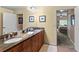 Double vanity bathroom with granite countertops and adjacent bedroom view at 6312 Buford St # 303, Orlando, FL 32835