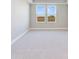 Bright bedroom with neutral walls and carpet, featuring two large windows with a view at 7521 Laureate Blvd # 5304, Orlando, FL 32827